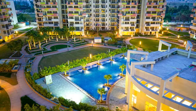 Bestech Park View Sanskriti - aerial of pool and clubhouse at dusk thumbnail